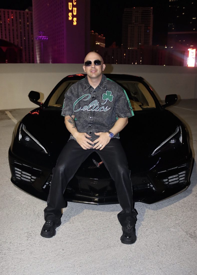 Camisa denim Celtics y pantalón de cuero negro sobre un Corvette